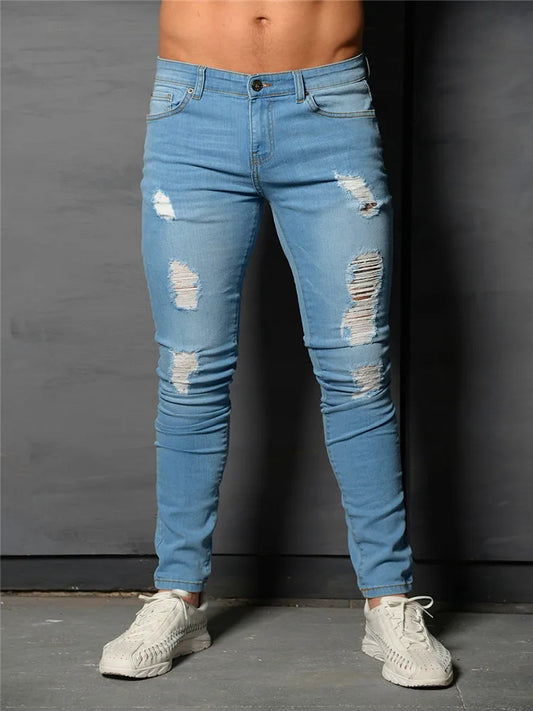 Person wearing light blue distressed jeans against a dark background