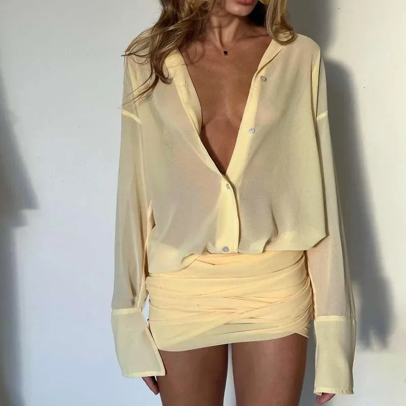 Woman wearing a sheer yellow blouse and skirt against a white background