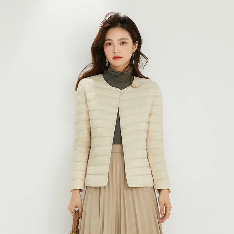 Woman wearing a beige puffer jacket against a white background