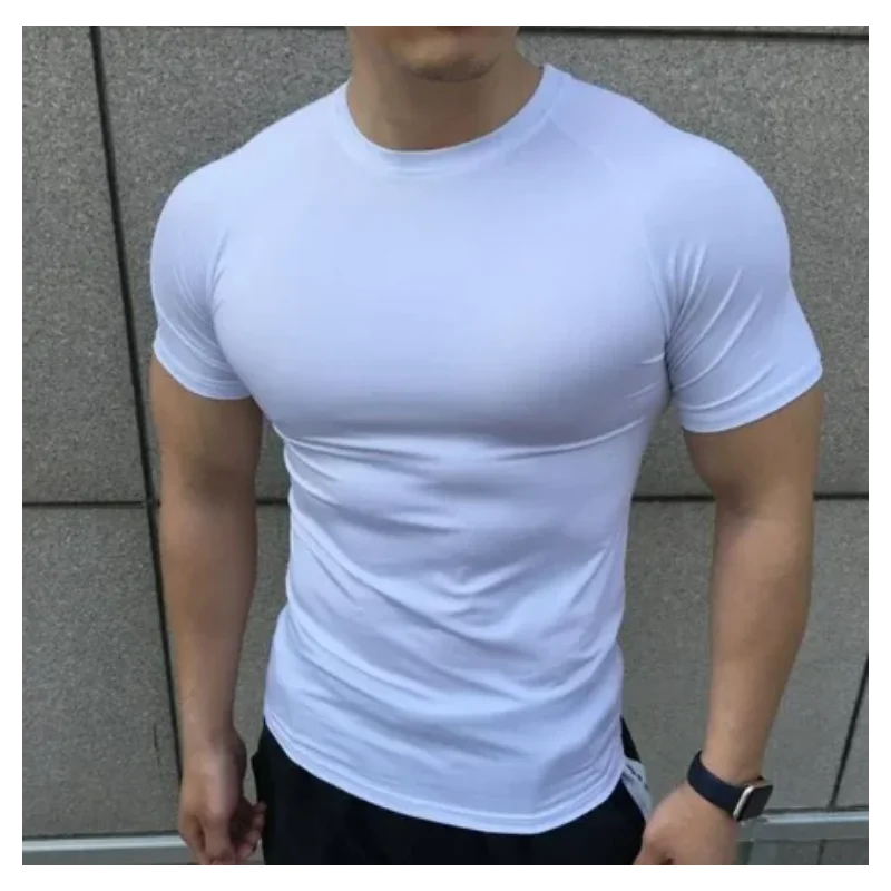 Person wearing a white t-shirt against a gray wall