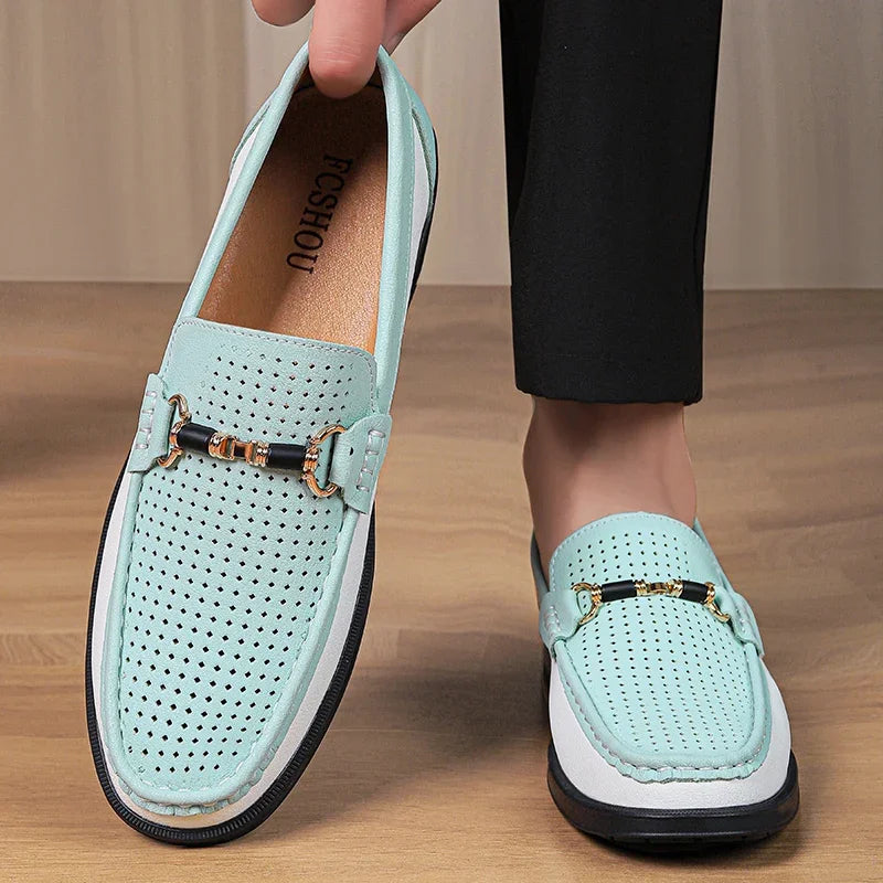 Light blue loafers with gold accents worn by a person on a wooden floor.