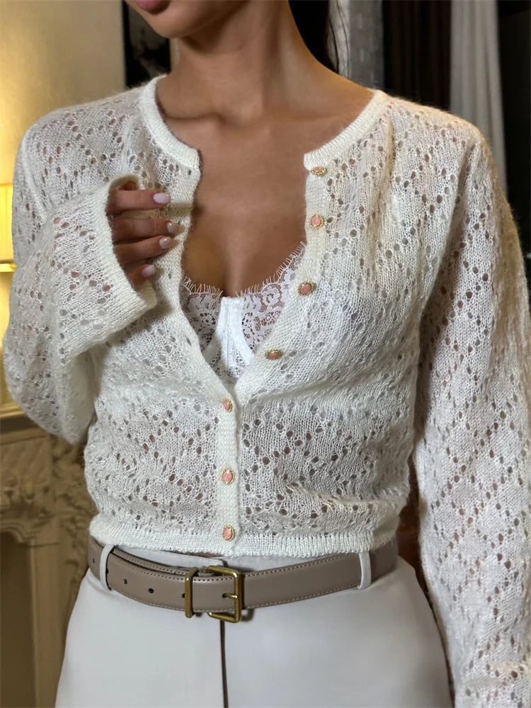 White lace cardigan worn by a person with a blurred background