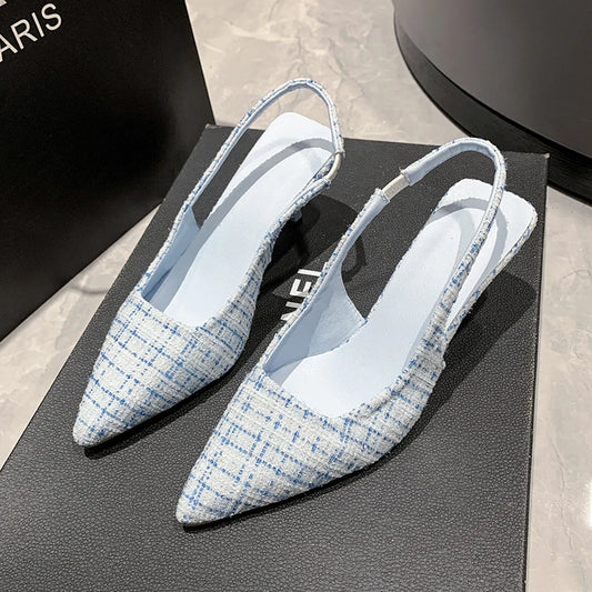Pair of blue and white checkered slingback shoes on a black surface.