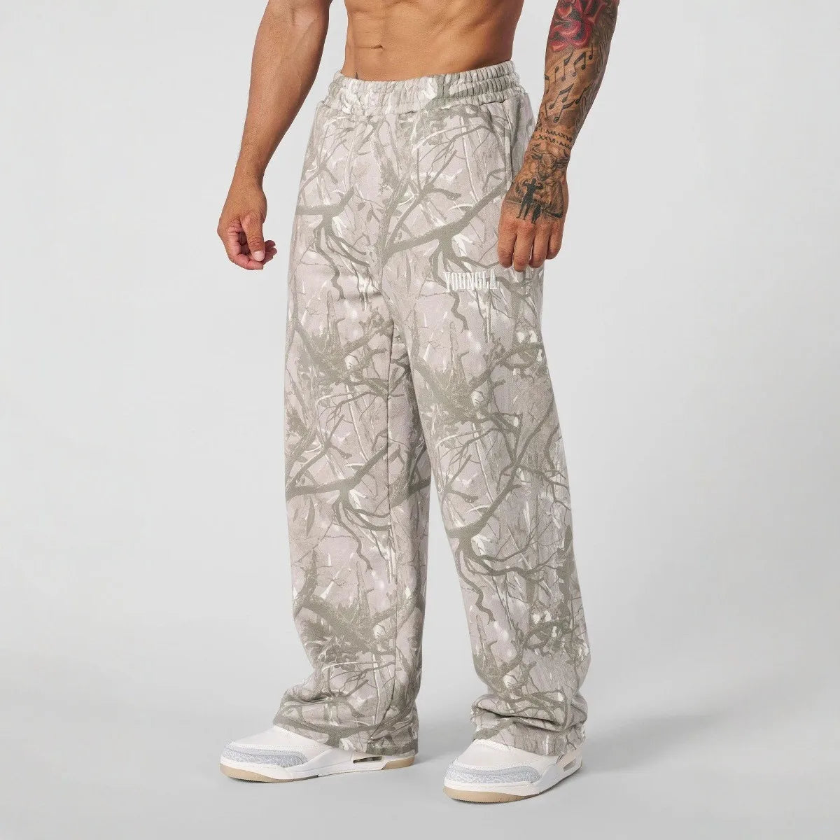 Person wearing camouflage pants on a plain background