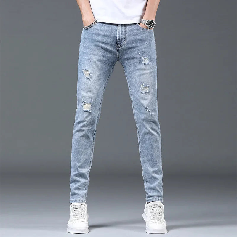 Light blue distressed jeans worn by a person on a gray background