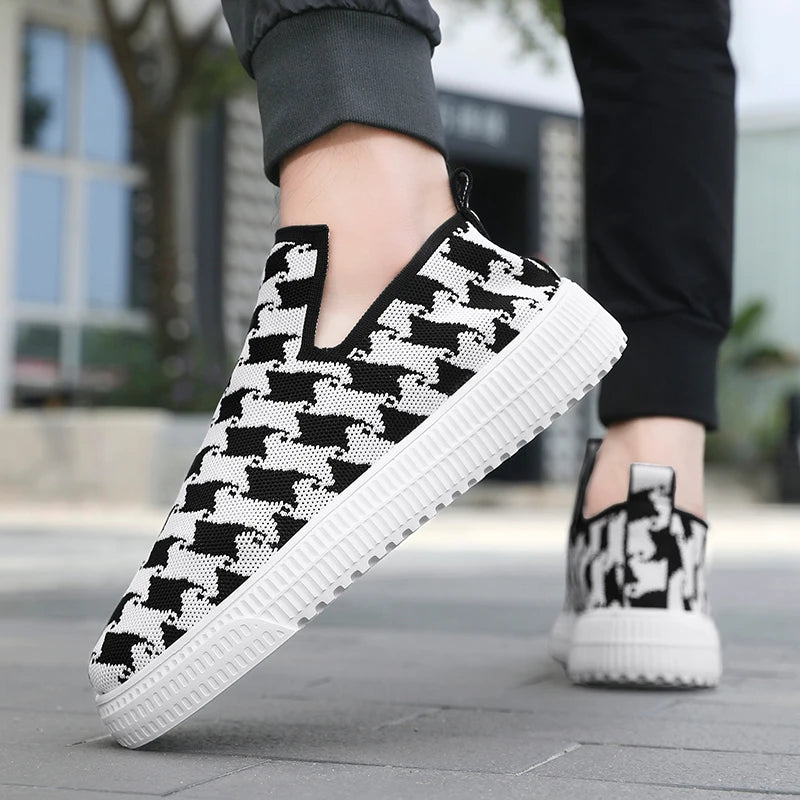 Black and white patterned slip-on shoes on a blurred outdoor background
