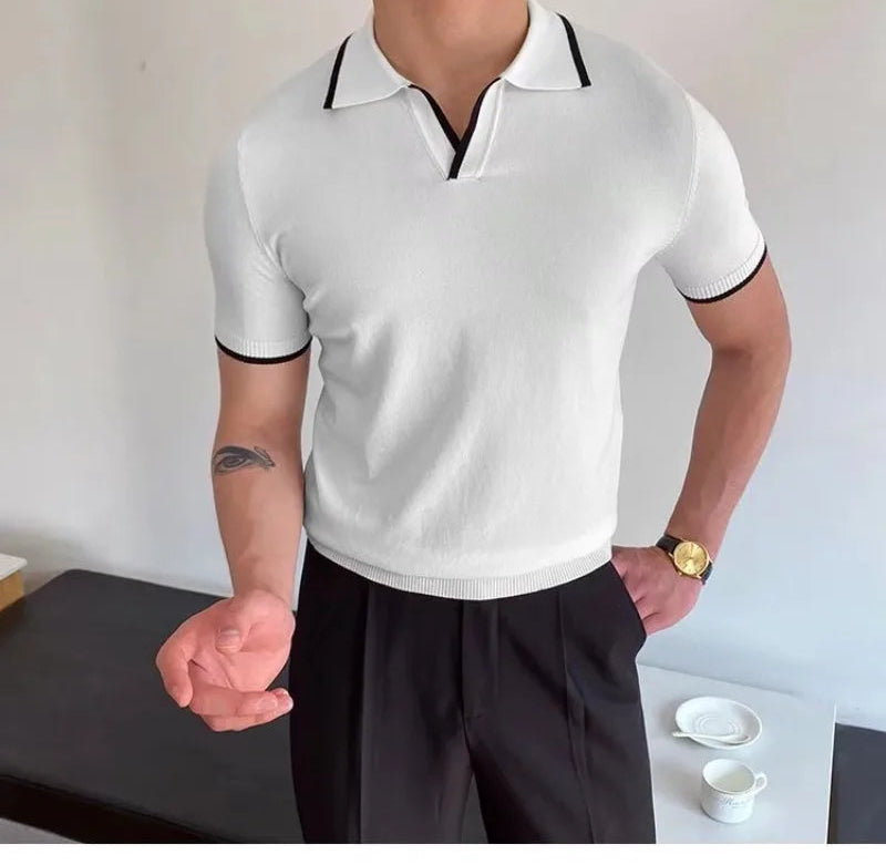 Person wearing a white polo shirt with black trim in an indoor setting.