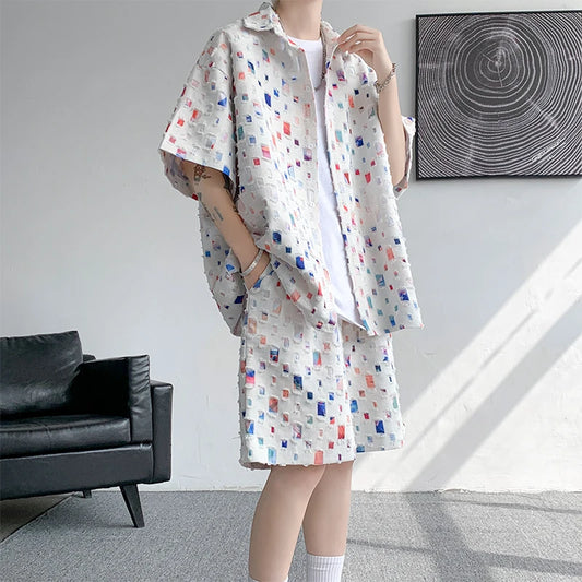 Person wearing a patterned outfit in a room with a black sofa and abstract wall art.