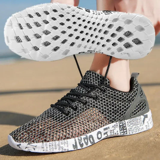 Black and gray sneaker with white sole on a sandy background