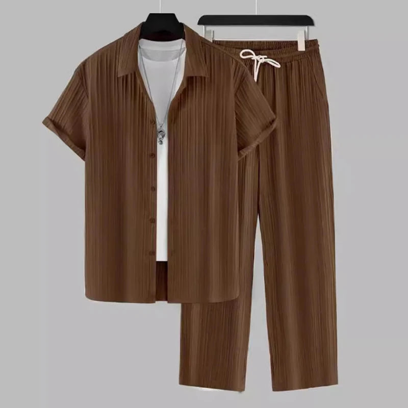 Brown shirt and pants set on hangers against a gray background