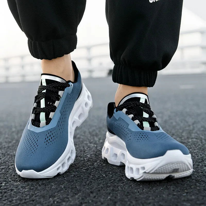 Blue running shoes with white soles worn by a person on a road.