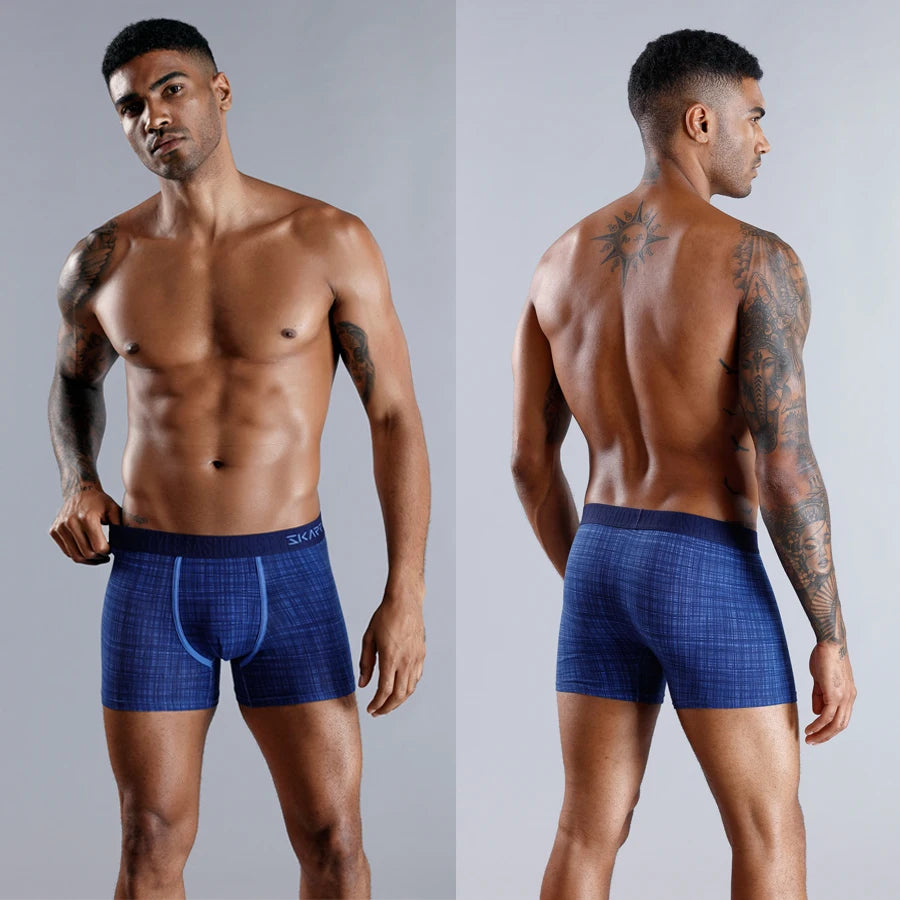 Man wearing blue boxer briefs on a gray background