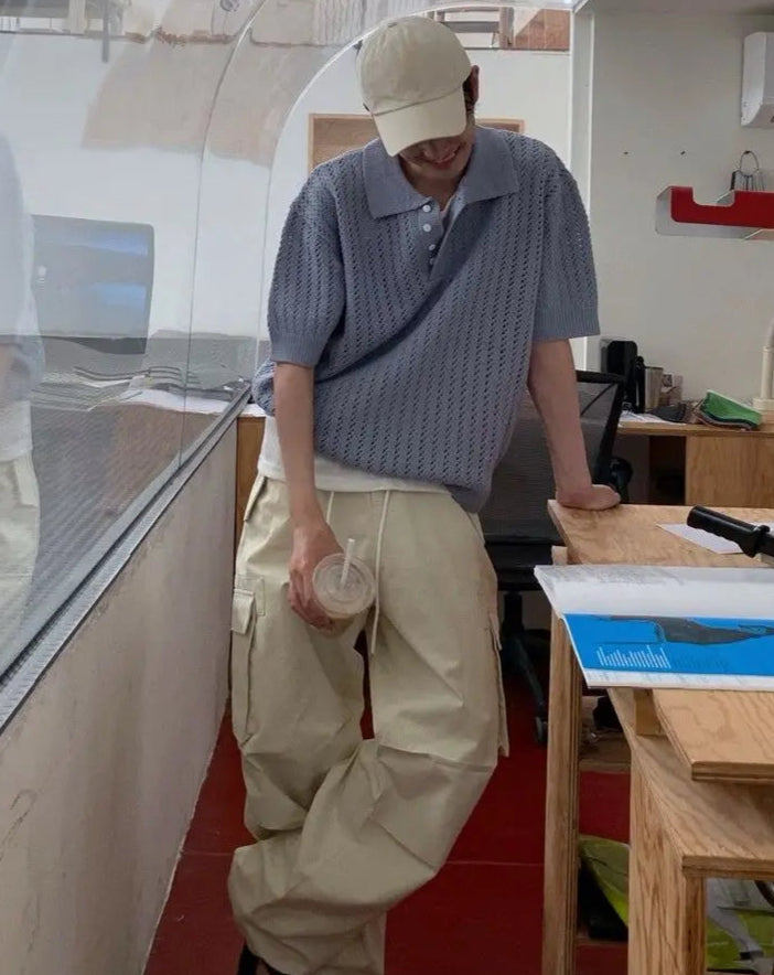 Person standing in a modern office space with large windows.