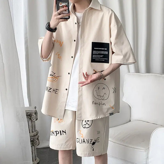 Person wearing a beige shirt and shorts with text and graphics, standing against a white curtain.