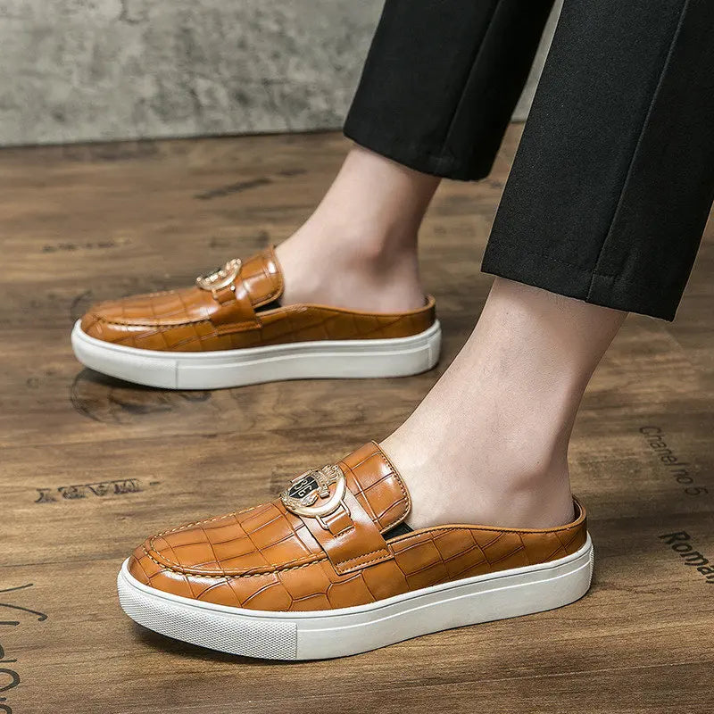 Brown loafers with white soles worn by a person on a wooden floor.