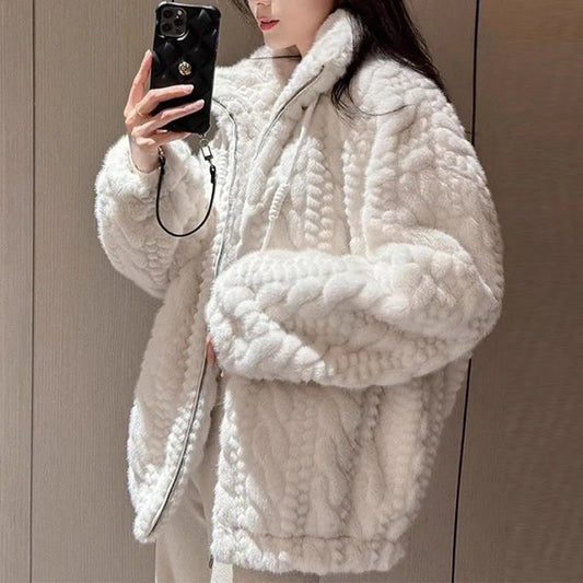 Person wearing a white textured coat taking a mirror selfie.