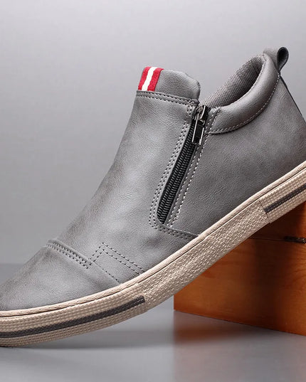 Gray slip-on shoe with a zipper on a gray background