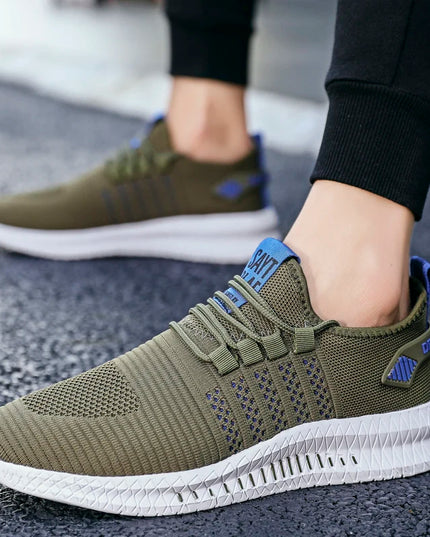 Green athletic shoes with white soles worn by a person on a textured surface