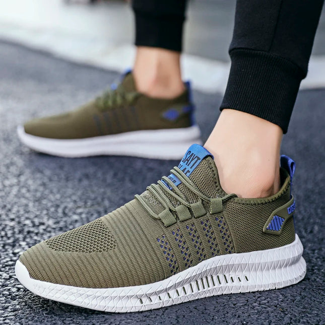 Green athletic shoes with white soles worn by a person on a textured surface