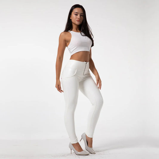 Woman wearing a white sleeveless top and pants on a plain background