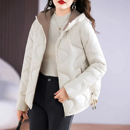 Woman wearing a light-colored puffer jacket with a blurred background