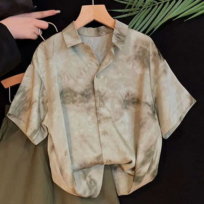 Tie-dye shirt on a hanger against a black background