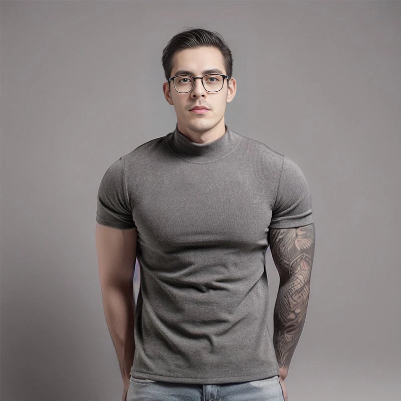 Man wearing a gray turtleneck shirt against a plain background