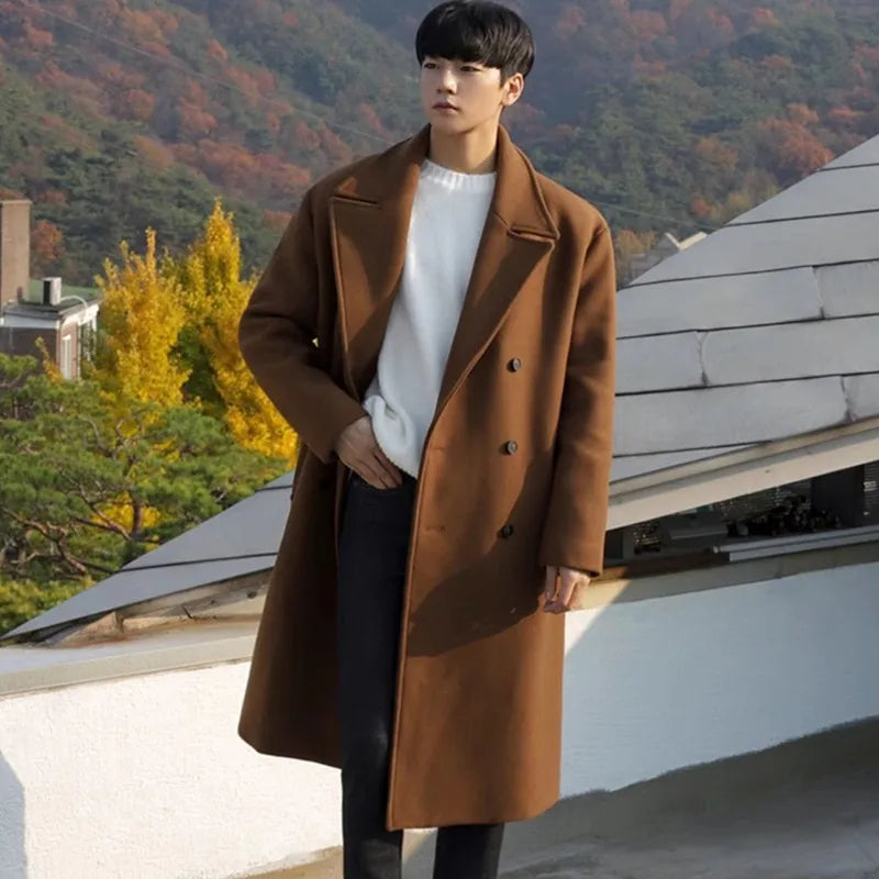 Person wearing a brown coat standing on a rooftop with autumn foliage in the background