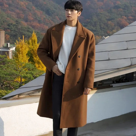 Person wearing a brown coat standing on a rooftop with autumn foliage in the background