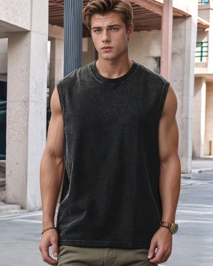 Man wearing a black sleeveless shirt and green pants standing in an urban setting.