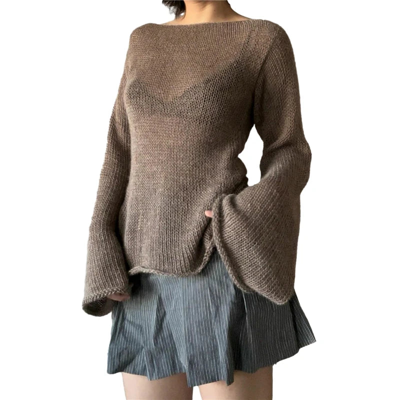 Person wearing a brown sweater and gray pleated skirt on a white background