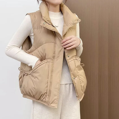 Person wearing a beige puffer vest against a neutral background