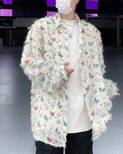 Person wearing a white coat with colorful butterfly patterns in an indoor setting.