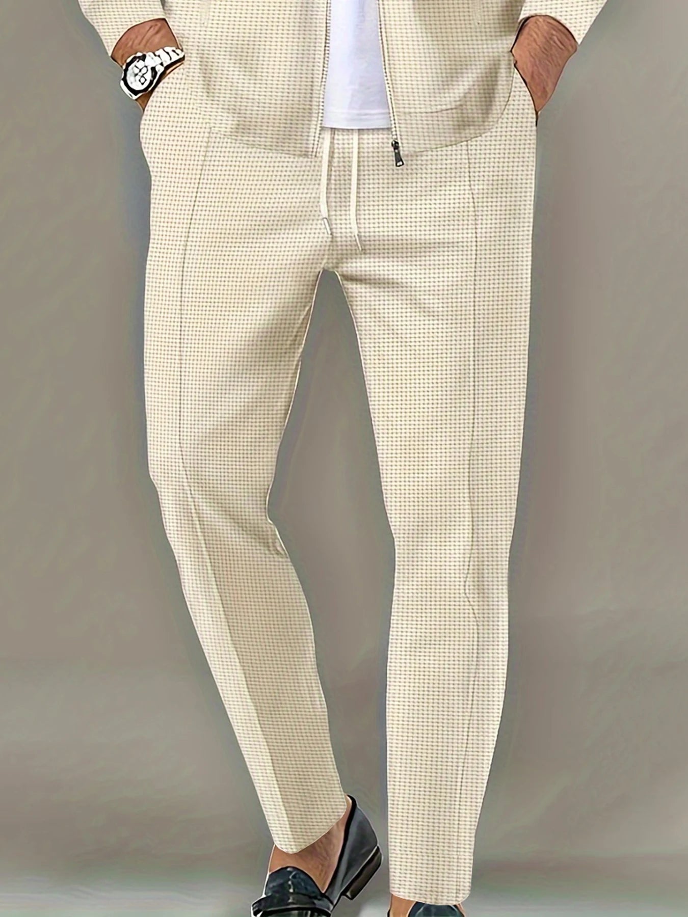 Beige checkered pants worn by a person on a plain background