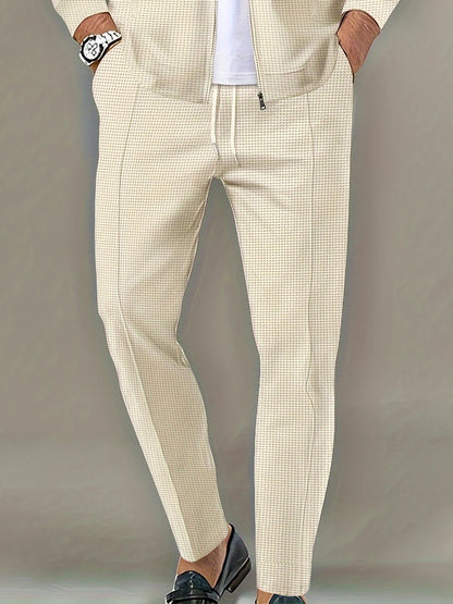 Beige checkered pants worn by a person on a plain background