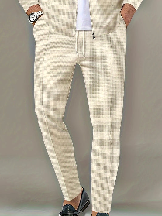 Beige checkered pants worn by a person on a plain background