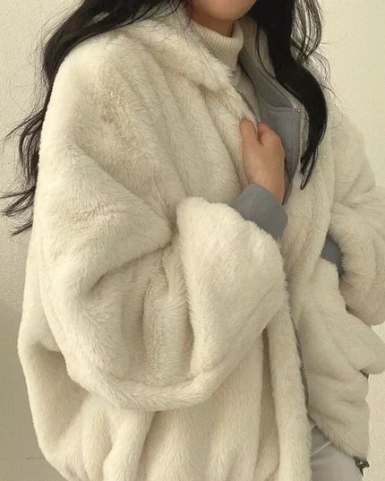 Person wearing a fluffy white coat against a neutral background