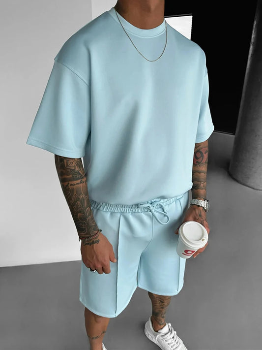 Person wearing a light blue outfit holding a coffee cup indoors.