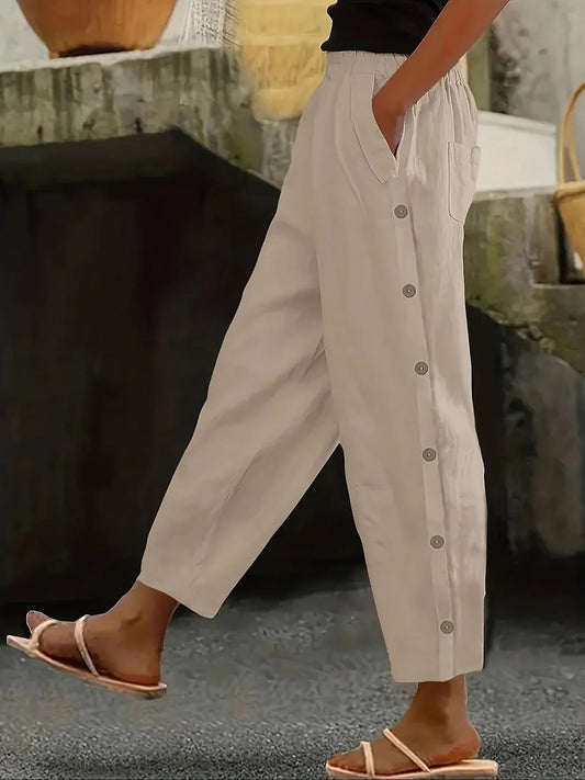 Person wearing beige button-up pants with a blurred background