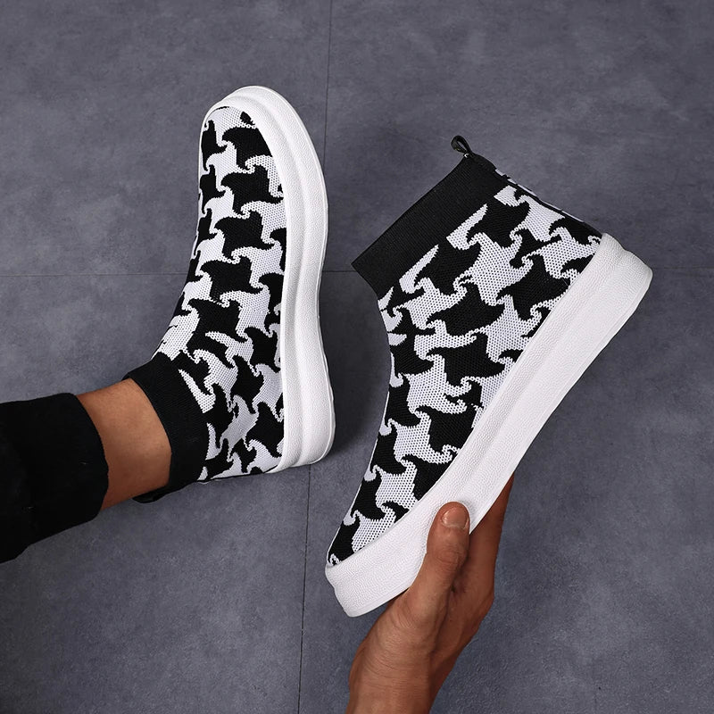 Black and white patterned slip-on sneakers on a gray background