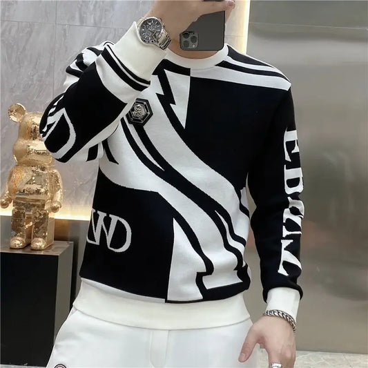 Person wearing a black and white patterned sweater with visible branding.