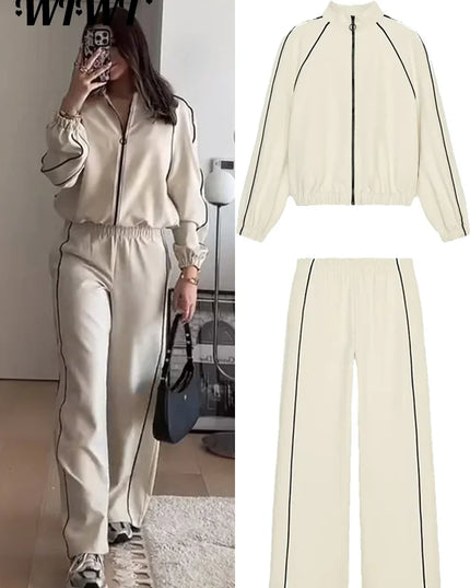Woman taking a mirror selfie wearing a cream-colored tracksuit with black accents, with an inset showing the outfit details.