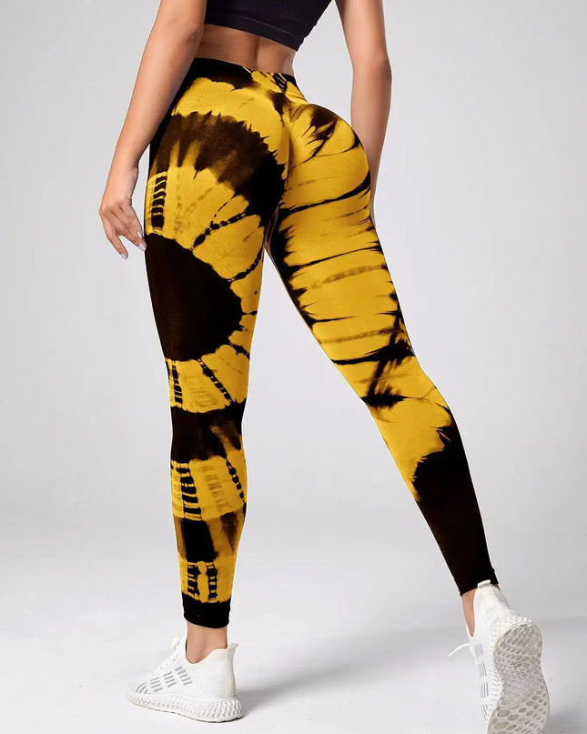 Yellow and black tie-dye leggings worn by a person on a gray background