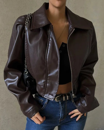 Person wearing a brown leather jacket and blue jeans against a neutral background