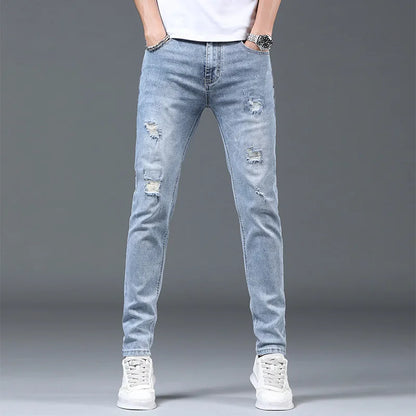 Light blue distressed jeans worn by a person on a gray background