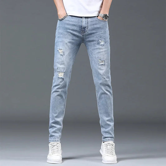 Light blue distressed jeans worn by a person on a gray background