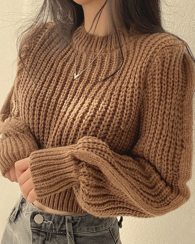 Person wearing a brown knitted sweater against a neutral background