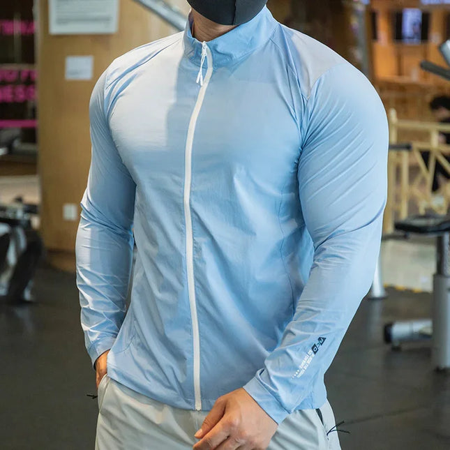 Person wearing a light blue athletic jacket with a white zipper in an indoor setting.