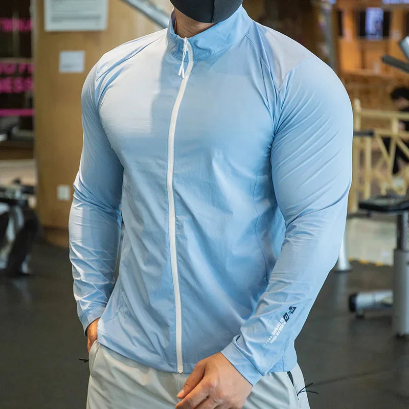 Person wearing a light blue athletic jacket with a white zipper in an indoor setting.