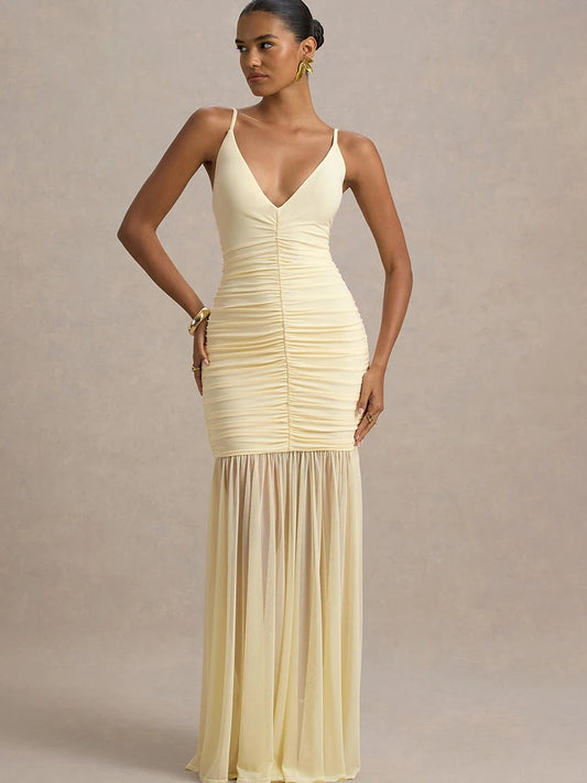 Woman wearing a light yellow evening gown against a neutral background